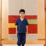 Smiling boy in blue organic cotton block print kidswear with relaxed fit, neutral background
