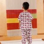 Toddler in organic cotton pajamas with purple elephant print, standing indoors.