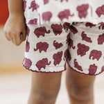 Child wearing white organic cotton shorts with maroon elephant block print pattern