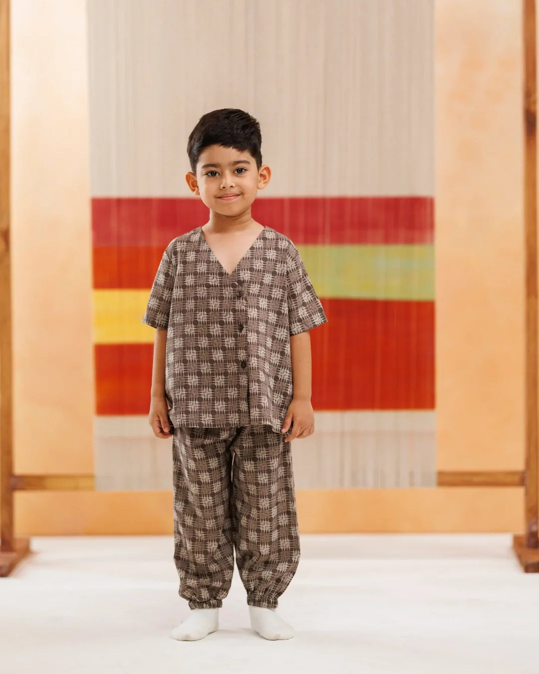 Young boy wearing organic cotton printed kidswear set with short sleeves and matching pants