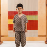 Young boy wearing organic cotton printed kidswear set with short sleeves and matching pants