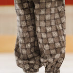 Child wearing loose-fit organic cotton pants with brown geometric block print pattern