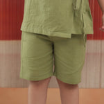Child wearing light green organic cotton shorts and top set, sustainable kidswear